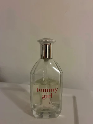 Tommy Girl parfym från Tommy Hilfiger 100 ml  - Fräsch parfym från Tommy Hilfiger, Tommy Girl. Flaskan är genomskinlig med silverfärgad kork och röd text. Klassisk och stilren design som passar perfekt i handväskan. Doften är lätt och ungdomlig.