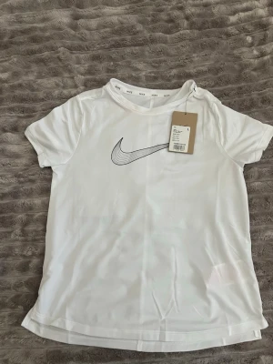 Vit Nike t-shirt - Säljer en vit t-shirt från Nike T-shirt aldrig använd !VIKTIGT! Barn storlek kolla mått på sista bilden💗
