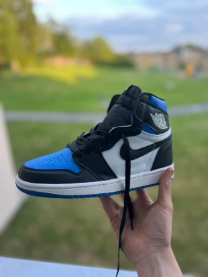 Nike Air Jordan 1 High blå/svart/vit - Säljer ett par Nike Air Jordan 1 High sneakers i blått, svart och vitt, skorna är i nyskick och skickar samma dag som köp 💕