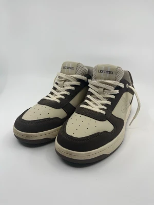 Les Deux beige och bruna sneakers - Säljer dessa snygga Les Deux Waris skor. Dem är använda några gånger men annars helt nya. Dem är inte smutsiga och har inga skador. Nypris är 1799kr. Hör av er vid frågor!😇Pris kan absolut diskuteras!