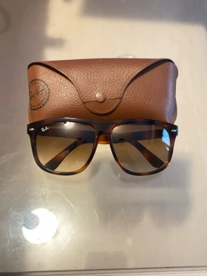 Bruna Ray-Ban boyfriend solglasögon - Snygga Ray-Ban solglasögon med brunt sköldpaddsmönstrat båge och bruna tonade glas. Klassisk fyrkantig form och Ray-Ban-logga på linsen. Kommer med brunt fodral i skinn-look. Bud är jag öppen för ,men håll det solklart 😎