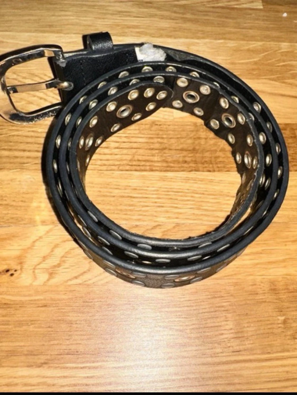 Svart bälte med nitar och hål