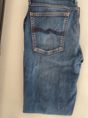 Blå jeans från Nudie Jeans - Säljer ett par klassiska blå jeans från Nudie Jeans. Skick 9,5 knappt använda. Pris kan diskuteras!