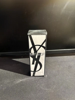 Yves Saint Laurent MYSLF EdP - Upptäck MYSLF Eau de Parfum från Yves Saint Laurent. Parfymen kommer i en stilren, rektangulär förpackning i svart och vitt med den ikoniska YSL-loggan. Doften är elegant och modern, perfekt för dig som vill sticka ut. Helt ny!!