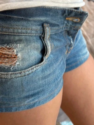 Low waist 2000s shorts - Säljer ett par low waist diesel jeansshorts med råa kanter och en snygg slitning vid fickan. Shortsen har fem fickor och guldfärgade sömmar. Köpte den i ett 2000s vintage affär från Kanada 