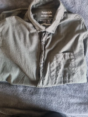 Grön långärmad skjorta Jack&Jones i Storlek S - Stilren grön skjorta från Jack&Jones med klassisk krage och bröstficka. Skjortan har långa ärmar och knäppning framtill. Den är i Storlek S men passar nog mellan 170-180. Använt i ungefär 1-2 år. Fortfarande jättebra skick, skrynklig från att blivit tvättad men det är bara att stryka sig fint. 