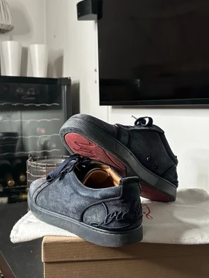 Christian Louboutin mörkblå - Säljer mina Christian Louboutins i storlek 44.5 då jag inte använder dem mycket längre, allt på bilderna tillkommer.     Skicket är inte det allra bästa därav priset, texten på innersulan har till mestadels fadeat bort. Sueden är lite smutsig men inget som inte går att rädda och det finns ett hål (bild 4) men inget som borde sticka ut något särskilt när du har på skon. Skriv gärna för mer frågor eller bilder!