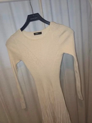 Beige ribbad långärmad klänning - Säljer en beige ribbad klänning från new yorker med lång ärm och rund halsringning. Klänningen är figurnära och har en mjuk, stickad känsla som passar perfekt till säsongens outfits.