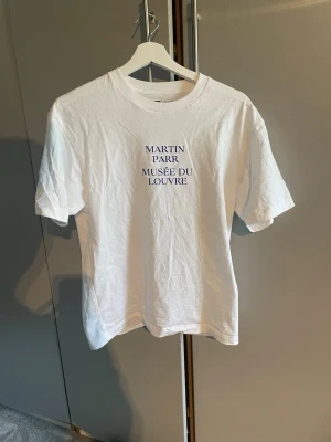 T-shirt från Uniqlo - Vit t-shirt med tryck fram och bak från Uniqlo. Använd 1 gång.