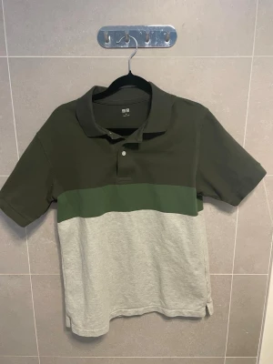 pikétröja Uniqlo - Snygg pikétröja från Uniqlo med blockfärger i mörkgrönt, grönt och ljusgrått. Tröjan har klassisk krage, korta ärmar och knappar framtill. Perfekt för en avslappnad och stilren look. skrivas ifall bra bilder krävs. Lite skrinkliga o så men det försvinner i tvätten eller om du ska strika dom eller hur du än gör