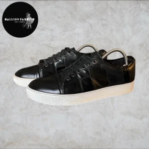 Lanvin skor storlek 41 / 42 - Lanvin skor med paneler i både blankt samt matt skinn och mocka. Väldigt snygga sticker ut lite mer än vanliga svarta lanvins.  Har några mindre defekter kontakta mig för mer info och bild. I övrig fint skick och mycket kvar att. Storlek 7 motsvara ungefär storlek 41-42. Fråga gärna om innermått vid osäkerhet! Endast skor, ingen og.                                                                                       Nypris 4000-6000 kr | Mitt pris: 899 kr