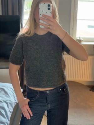 Mörkgrå kortärmad stickad tröja - Stickad mörkgrå tröja i storlek 170! Sitter som en S kan kanske passa XS beroende på hur man vill att den ska sitta men kan få liten då den är lite kortare i modellen! Aldrig använd endast testad!😊
