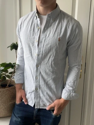 Ralph lauren skjorta  - Ralph lauren skjorta randig, lite ostruken. Inga defekter förutom minimala fläckar under armhålorna, syns lite mer i verkligheten än på bilden! Modellen i bilderna är 180 cm 75 kg och bär Storlek S slim fit , Kom med frågor! 🌟 (Kan gå ned i pris vid köp av paket 😉) 