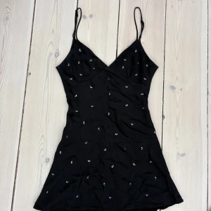 Svart klänning - Svart kortklänning med nitar, vissa nitar har ramlat av annars fin!🖤🌟🖤🌟