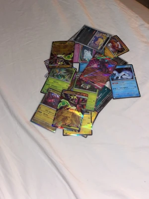 Pokemon Bulk Med Blandade Sets - Säljer en stor hög Pokémonkort flera holografiska och vanliga kort. Blandade språk, bland annat koreanska  japanska och engelska. Perfekt för samlare eller dig som vill utöka din samling med unika och sällsynta kort.