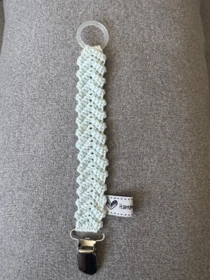 Virkad napphållare - Virkad, isblå napphållare, virkad av mig i 100% bomullsgarn med metallclips och silikonring.  Mönsterskapare: animo.design