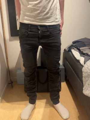 Svarta slim fit jeans från Replay - Säljer ett par svarta slim fit jeans från Replay med klassisk femficksdesign och dragkedja. Jeansen har en snygg, smal passform och är tillverkade i stretchigt material som sitter bekvämt. Perfekta för dig som gillar en modern och stilren look. Modellen är 182 och väger 75 kg💥💥