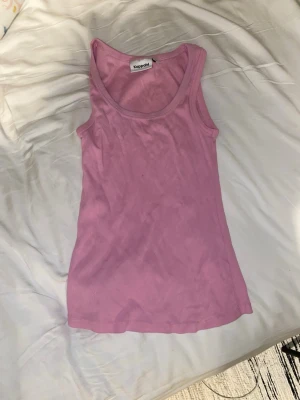 Rosa ribbad linnetopp från Kappahl - Säljer en ljusrosa ribbad linnetopp från Kappahl. Toppen är ärmlös med rund halsringning och har en slim passform. Perfekt att styla med jeans eller kjol för en fräsch look.