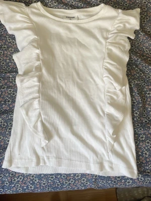 En jätte fin och snygg topp❤️ - Detta är en otroligt fin och somrig topp med vulang och bara en jätte fin vit färg. Den är i ett väldigt bra skick och har används någon enstaka gång.