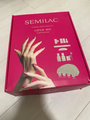 Semilac Hybrid Manikyrset Love Me - Komplett hybrid manikyrset från Semilac i rosa förpackning. Innehåller UV LED-lampa 24W/48 som funkar super bra, tre nagellacksfärger, oanvänd mattlack, baselack, toplack, nagelbandsremover, cleaner och pads. De flesta av produkterna är halva men kitet är perfekt för någon som vill börja eller testa naglar. 