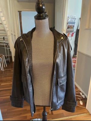 Svart skinnjacka från NA-KD - Super snygg och stilren skinnjacka från NAKD. Jättefint skick, storlek 34 men sitter lite lite oversized som den gör på dockan på bild 2🫶passar perfekt som jacka till vår och sommar
