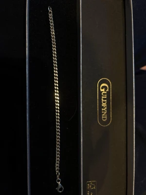 Äkta silver armband från Guldfynd - Armband i äkta silver från Guldfynd för killar. Aldrig använd då den var för liten. Kedjan har platta, tätt sammanlänkade länkar och ett rejält klolås som gör det enkelt att ta på och av. Perfekt accessoar för dig som gillar klassisk och enkel stil.