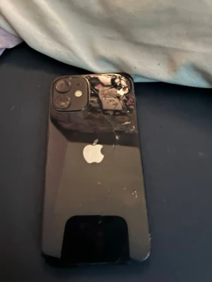 iPhone 12 mini - Säljer en iPhone 12 mini, baksidan är väldigt sprucken och sidan har några skråmor, skärmen är bra med bara små repor som inte märks, allt annat funkar perfekt, batterikapacitet 69% och 128GB lagring,