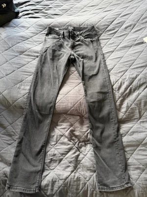 Jack & Jones slim Glenn - Säljer ett par gråa slim fit jeans med klassisk femficksdesign och bälteshällor. Jeansen har raka ben och är tillverkade i ett stretchigt denimtyg som ger en bekväm passform. Perfekta för en avslappnad och stilren look. Strl 29/32