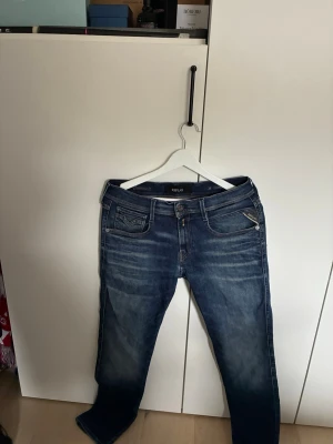 Blå Replay jeans - Snygga blå jeans från Replay. Jeansen har raka ben och normal midja, samt detaljerade sömmar på bakfickorna. Perfekta för en avslappnad och trendig look. Nypris 1700!