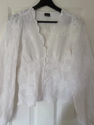 Vit broderad blus från Gina Tricot - Söt vit blus från Gina Tricot med broderade blommor och knappar framtill. Endast använd en gång❤️
