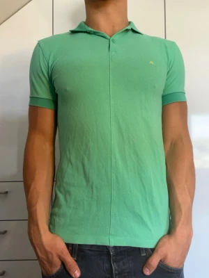 Grön pikétröja från J. Lindeberg - Grön piké från J.Lindeberg. Strl S. Inga defekter. Modellen är 178 cm och väger 77 kg. Hör gärna av dig vid frågor!