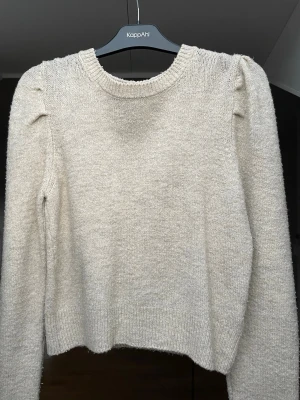 Beige stickad tröja  - Mysig beige stickad tröja från New Look med rund halsringning och diskreta puffärmar. 
