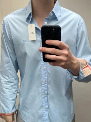 Burberry skjorta - Super fin ljusblå burberry skjorta i storlek L, som är i mycket bra skick. Nypris 5000kr mitt pris endast 1000kr. Hör gärna av er vid frågor eller funderingar. Mvh Trend closet😊