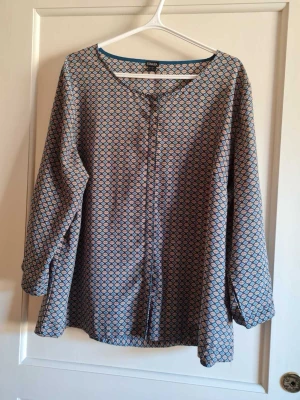 Mönstrad blus från Esmara strl 48 (dam) - Säljer en snygg mönstrad blus från Esmara. Blusen har långa ärmar och ett geometriskt mönster. Blusen har dolda knappar fram. Storlek EUR 48. Kan hämtas i Vallentuna.
