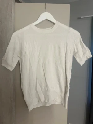 Vit t-shirt från Zara/sweter - En enkel och stilren vit t-shirt från Zara i storlek S. T-shirten har rund halsringning och korta ärmar. Materialet känns mjukt och passar perfekt till alla typer av outfits. Klassisk modell som är lätt att matcha.
