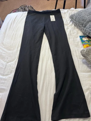 Svarta bootcut leggings  - Snygga svarta leggings med bootcut-ben och hög midja. Tillverkade i mjukt och stretchigt material som sitter skönt på kroppen. Perfekta för dig som gillar en enkel men trendig look.