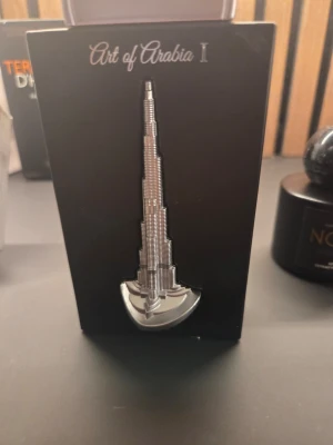 Art of Arabia I parfym - Unik parfymflaska från Art of Arabia I, inspirerad av Burj Khalifa. Flaskan är silverfärgad och har en modern, stilren design som sticker ut i parfymhyllan. Perfekt för dig som gillar exklusiva och annorlunda dofter.