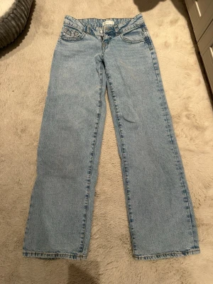 Ljusblå raka jeans med låg midja från Gina Tricot - Säljer ett par ljusblå jeans med raka ben och låg midja. Klassisk femficksmodell med knapp- och dragkedjegylf. Jeansen har en avslappnad passform och är tillverkade i denim. Perfekta för en casual och trendig look. Ganska nya och har knappt använt, legat i garderoben. Rensar just nu ut jeans 