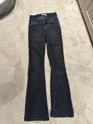 Mörkblå bootcut jeans från Gina tricot - Snygga mörkblå bootcut jeans med klassisk femficksdesign och låg midja. Jeansen har utsvängda ben och är tillverkade i ett mjukt denimtyg som ger en skön passform. Perfekta för dig som gillar en retroinspirerad look. Använda många gånger men har inte använt dem på ett långt tag utan ba legat i garderoben som fick hänga med ut från rensningen 