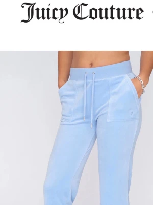 Blåa Juicy Couture byxor  - Snygga ljusblå mjukisbyxor från Juicy Couture i mjuk velour. Byxorna har bred resår i midjan med dragsko, stora fickor fram och bak med knappdetaljer. Perfekta för en avslappnad och trendig look.🥰
