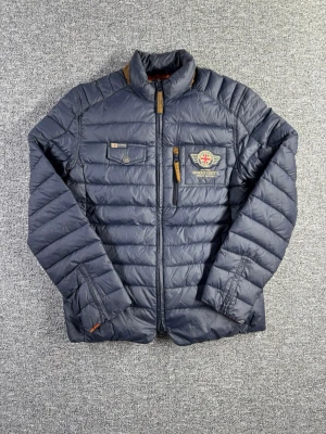 Morris dunjacka S marinblå – lätt & stilren - Snygg dunjacka från Morris Stockholm i storlek S. Lätt, smidig och perfekt som vår/höstjacka eller som extra lager på vintern. Klassisk marinblå färg med fina detaljer.  📏 Storlek: S 📐 Mått visas i bilderna ✨ Skick: Bra skick med en liten defekt – detta visas tydligt i bilderna  Perfekt kombination av stil och funktion.  💸 Följ mig så får du 10% rabatt på köpet!