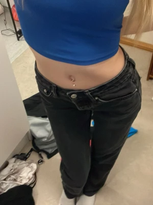 Svarta low waist jeans - Säljer ett par svarta low waist jeans med raka ben och klassisk femficksmodell. Jeansen har silverfärgade knappar och nitar, samt bälteshällor. Perfekta för en trendig och avslappnad stil.