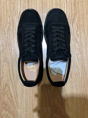 Svarta sneakers  - Säljer ett par Louboutin skor i jättefint skick. De är helt nya och aldrig använda, så skicket är som nytt. Tyvärr finns ingen originalförpackning kvar, då det var ett tag sedan de köptes.