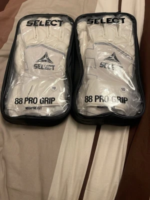 Select 88 Pro Grip målvaktshandskar - Säljer två par vita Select 88 Pro Grip målvaktshandskar med negative cut i storlek 10. Helt oanvända. Vill du bara köpa ett par skirv privat så diskuterar vi pris