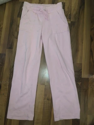 Ljusrosa mjukisbyxor med raka ben - Säljer ett par ljusrosa mjukisbyxor med raka ben och resår i midjan samt dragsko. Byxorna har två stora fickor fram och är gjorda i mjukt sweatshirtmaterial, perfekt för chill dagar. Ett litet märke går bort med tvättmedel 😉