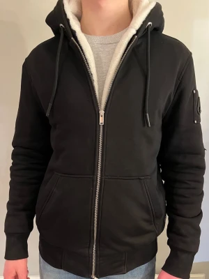 Moose Knuckles - Använd ett fåtal gånger. Den är perfekt för vinter, vår eller höst. Pälsen är vit, fläckfri och mycket bekväm. Det går även att ta av pälsen för varmare väder. Finns en liten defekt på vänstra armen som syns om man zoomar in på bild 3, annars är den fläckfri. (Kvitto finns). Hör gärna av er för fler bilder eller frågor.