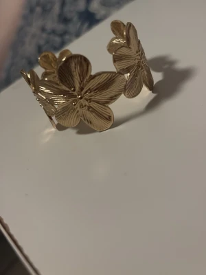 Guldfärgat armband med blommor - Aldrig använt Armand är lite för stort för mig 