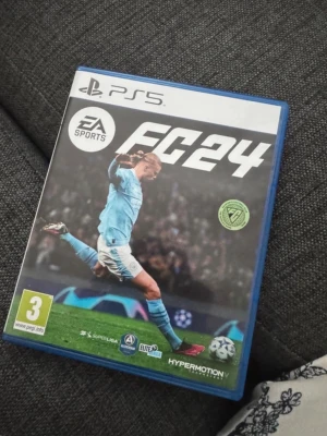 EA Sports FC24 till PS5 - Säljer spelet EA Sports FC24 till PlayStation 5. Omslaget är blått och spelet har en fotbollsspelare i ljusblå matchställ på framsidan. Perfekt för dig som gillar fotbollsspel och vill ha senaste versionen till PS5.