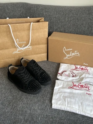 Christian Louboutin skor svart  - Hej! Väldigt exlusiva handgjorda Christian Louboutin skor i svart fin mocka med nitar och självklart med den röda sulan! Enligt mig en av de fetaste skorna som man kan bära. Påse, box, 2st dustbags och nitpåse med 2 extranitar medföljer i köpet! Nyvärde: 10000kr. Passar att ha varje dag men också under fina tillfällen! Skorna är som nya! Inga defekter förekommer och skorna är garanterat 100% autentiska vilket jag står för! Skorna är nyimpregnerade och klara för nästa användare! Hör gärna av dig😊