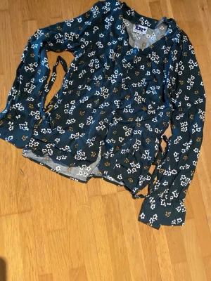 Retro blus - Mörkgrön blus med långa ärmar och knytband i midjan. Står strl 38 men den är liten